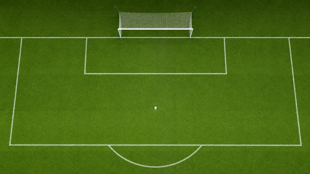 Vista de cima da grande area de futebol com a marca do penalti, o arco penal (meia-lua) e o gol ao fundo.