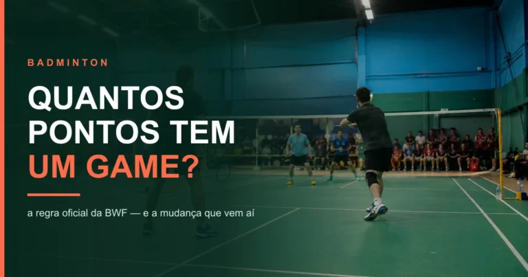 Partida de badminton em ginásio, com atleta preparando o golpe e a rede atravessando a quadra verde